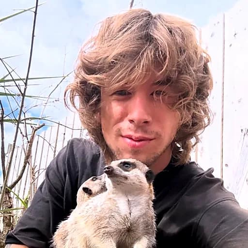 Francis holding two meerkats