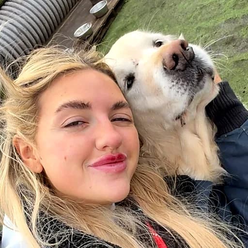 Lydia cheek to cheek with a golden retriever